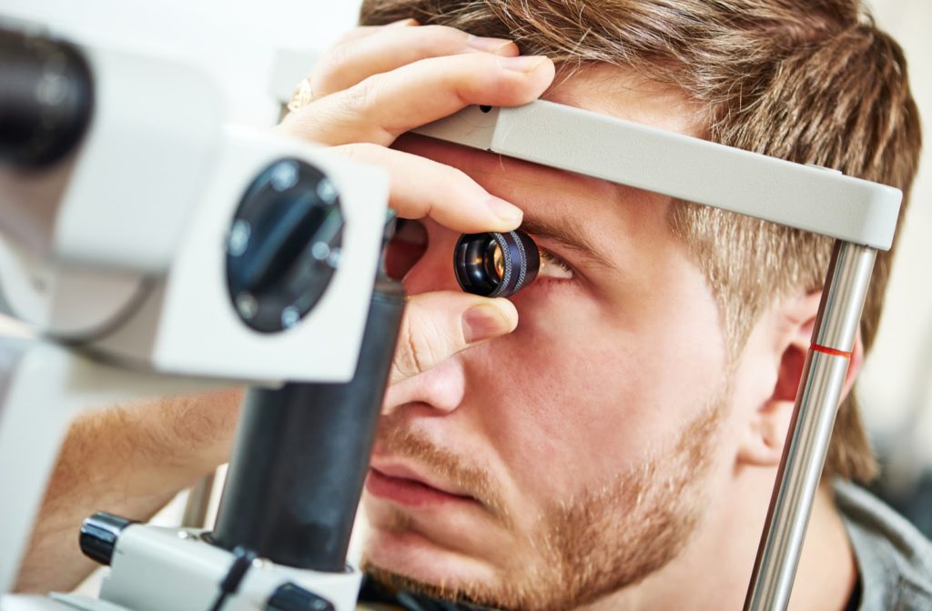 Young man undergoing eye exam by his optometrist