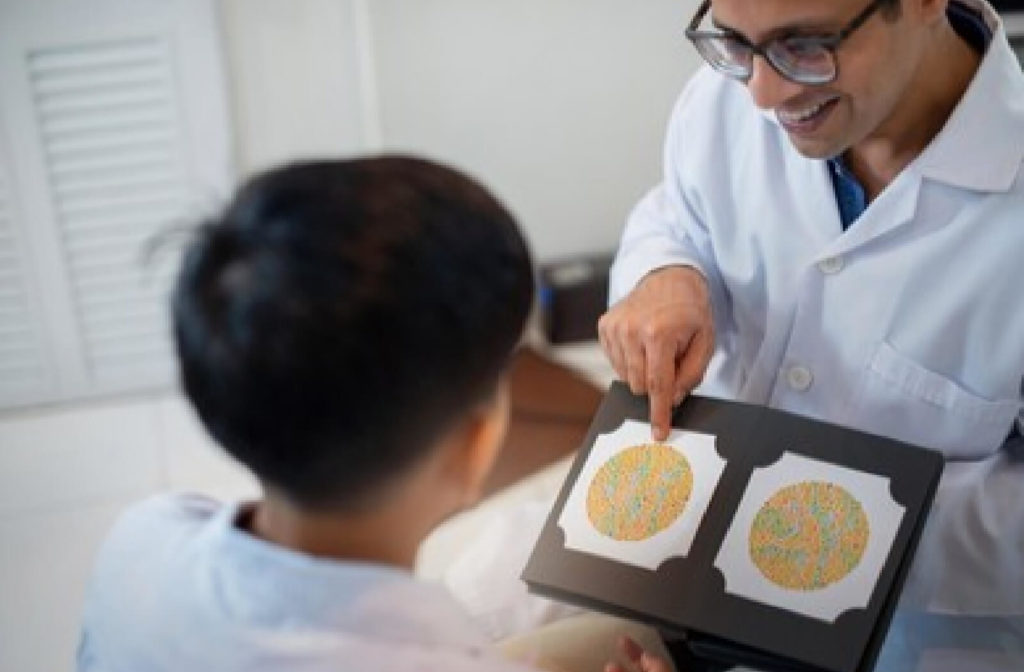 A male optician is doing a color blindness tested on a  child boy.