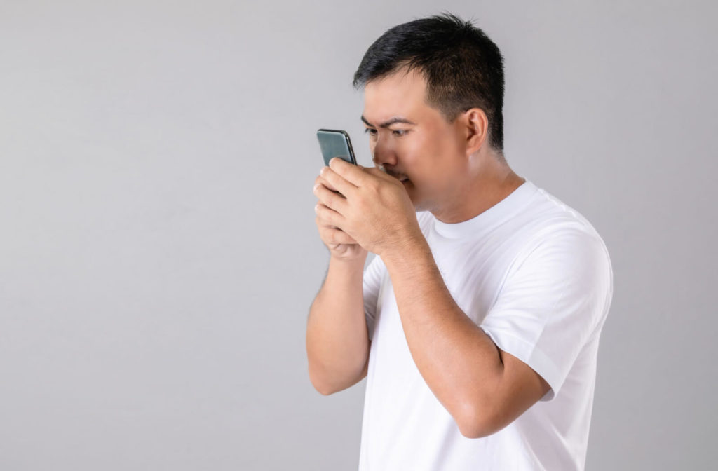 A man holding his smartphone very close to his face.