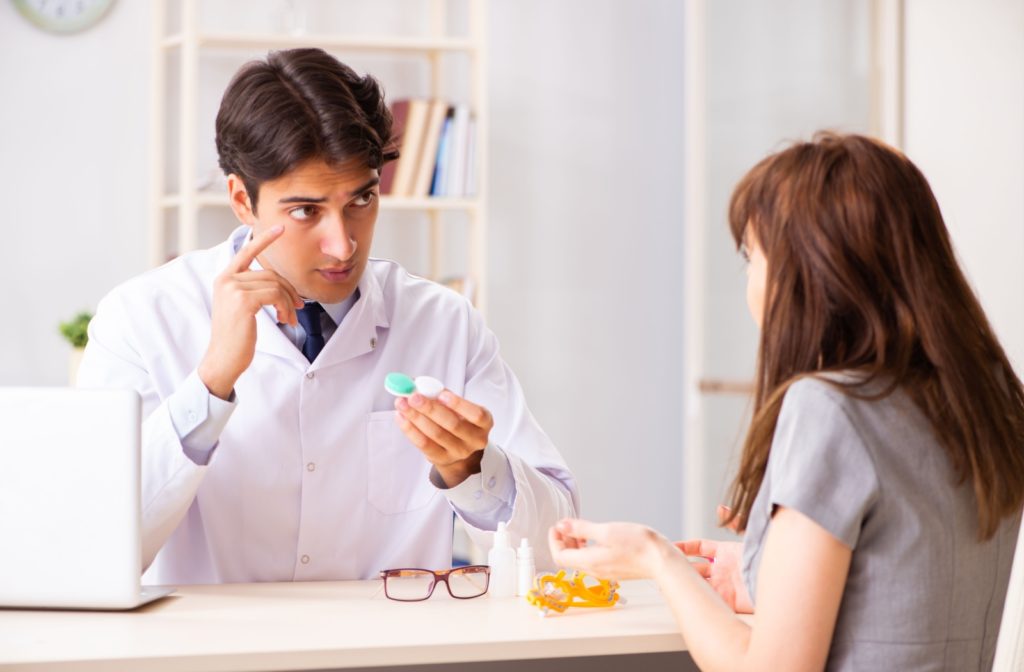 An optometrist explains to a patient how medically necessary contact lenses work better than eyeglasses for them