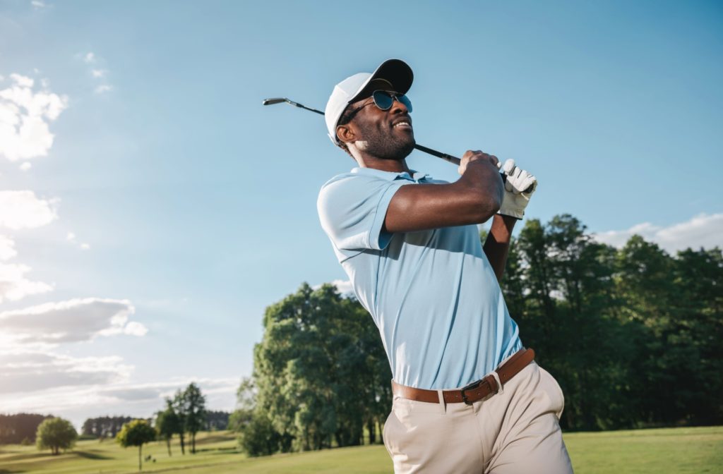 A golfer wearing polarized sunglasses to protect their eyes from the sun