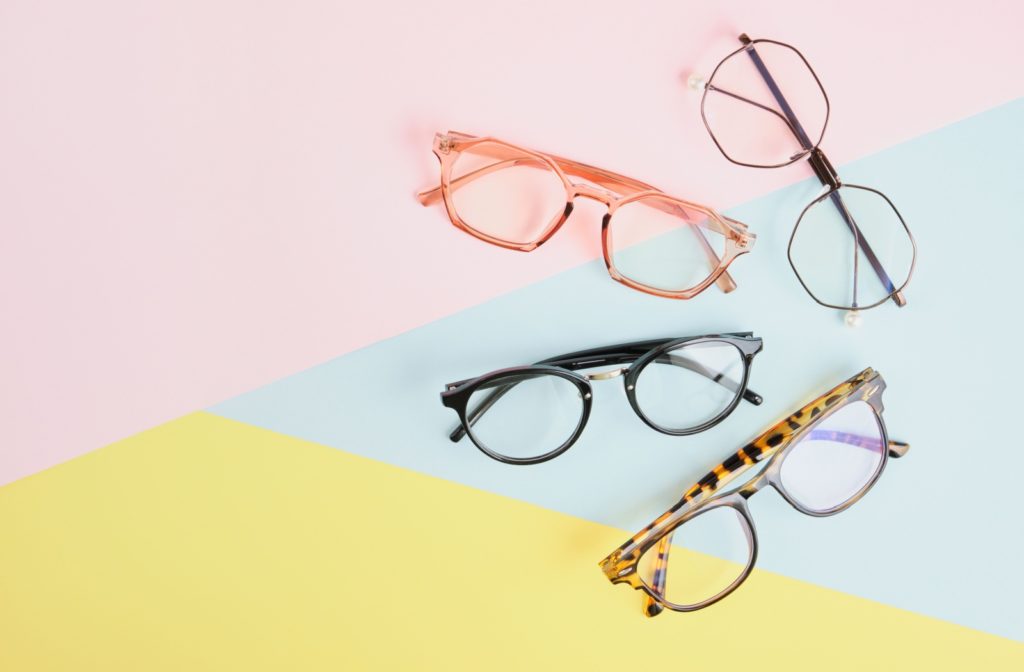 4 pairs of different eyeglasses on a multi-colored background.