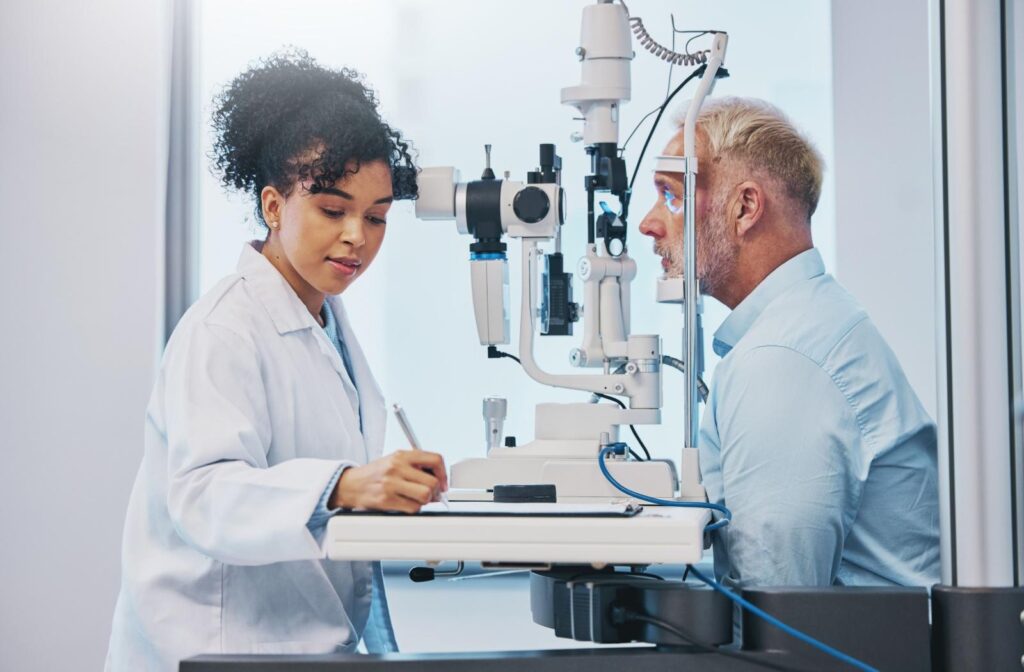 An older adult having their eyes examined by optometrist to monitor common eye conditions that develop with age.
